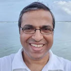 A man smiling by the water.
